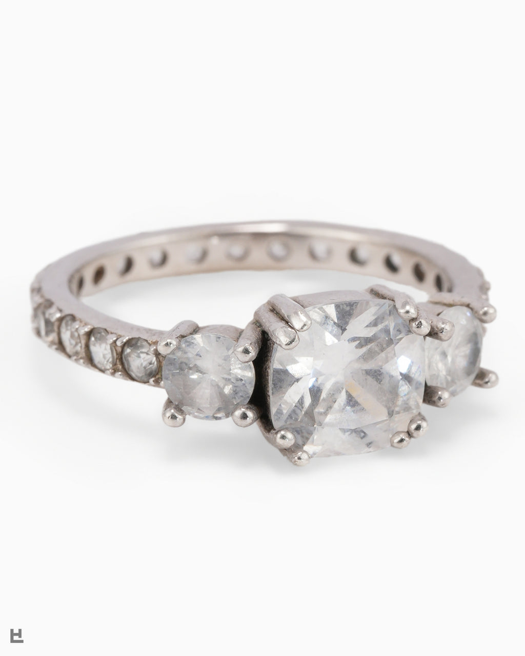 Bague trois pierres avec centre taille coussin et anneau entièrement serti