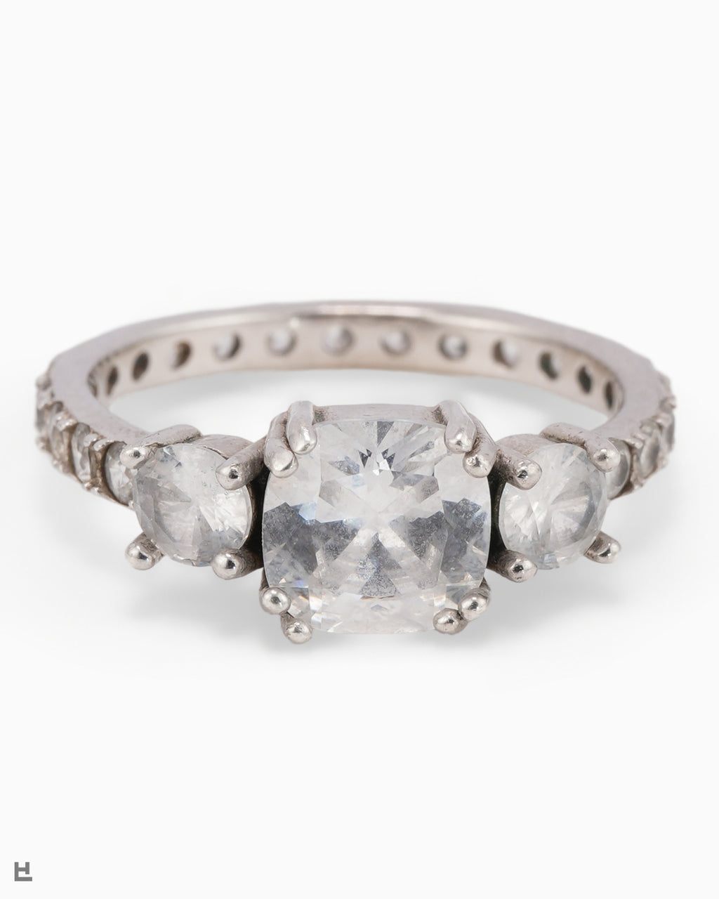 Bague trois pierres avec centre taille coussin et anneau entièrement serti