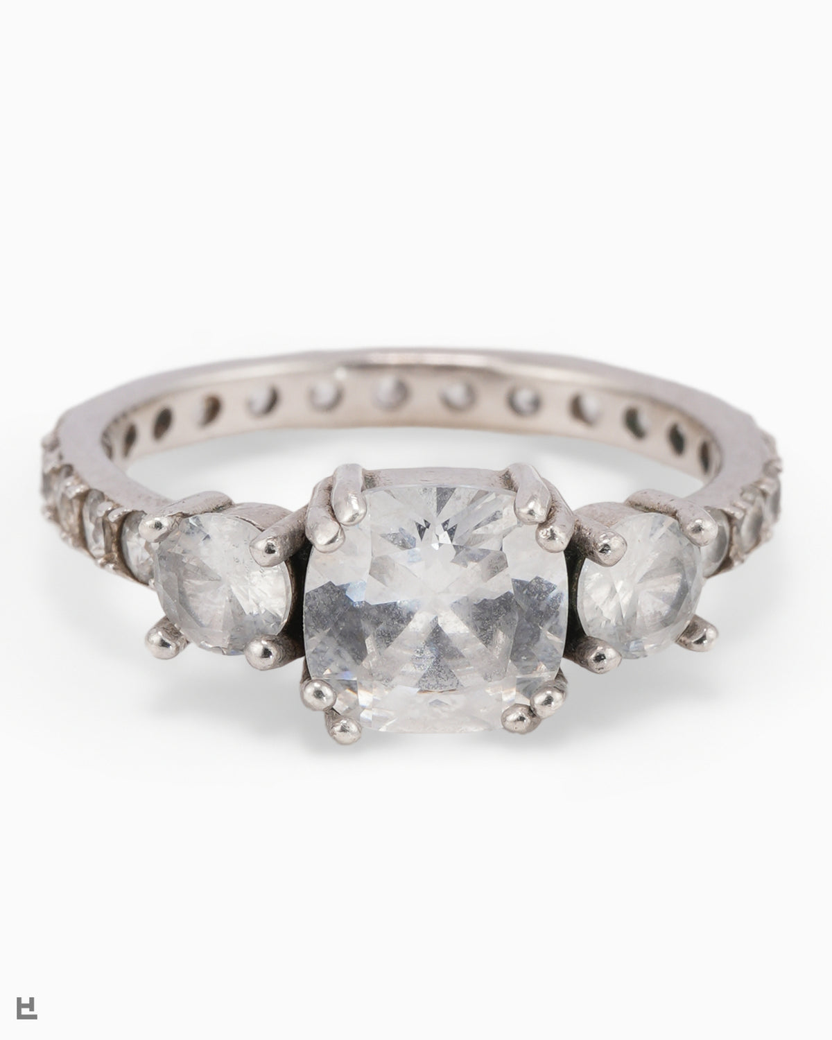 Bague trois pierres avec centre taille coussin et anneau entièrement serti